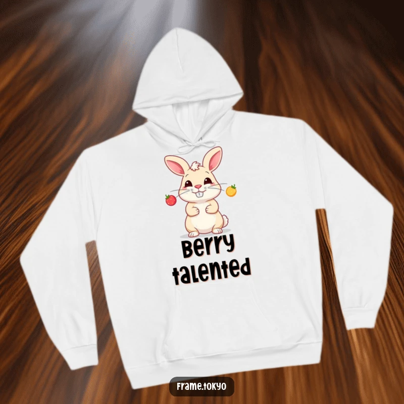 Funny hoodie design of a grinning rabbit performing an impressive juggle with three small, radiant, glowing berries.
