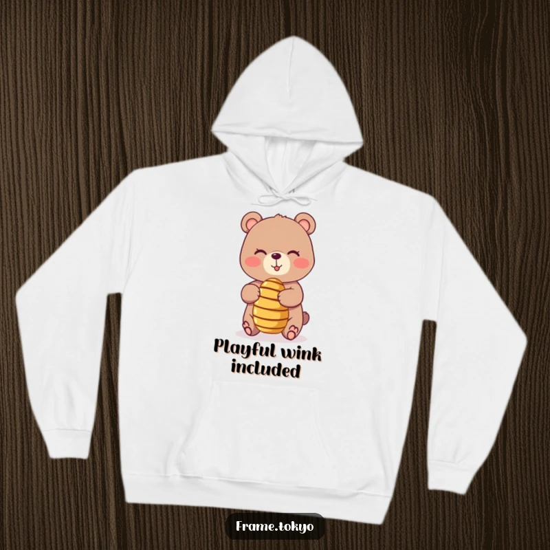 Funny hoodie featuring a playful, winking bear balancing a tiny, spinning honey dipper, offering warmth and a humorous, sweet design.