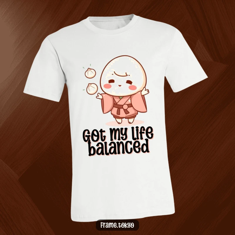 Funny mochi character wearing a kimono, juggling three small dumplings, printed on a soft graphic t-shirt.